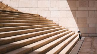 Toddler standing at the bottom of a stone staircase